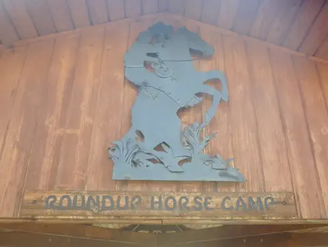 A metal sculpture depicting a cowboy on a bucking bronco at Roundup Horse Camp