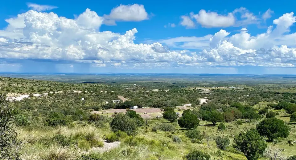 View of Pine Springs Campground as seen from the Guadalupe Peak trail. Campground and trailhead parking area surrounded by desert vegetation.