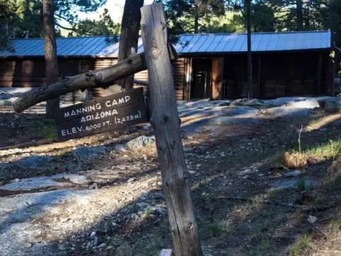 Manning Camp Cabin with 8,000 ft elevation sign