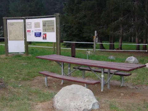 Picnic table with kiosk in background.