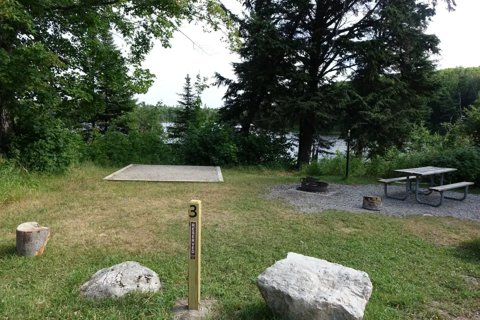 Campsite at campground with tent spot, picnic table, and fire pit