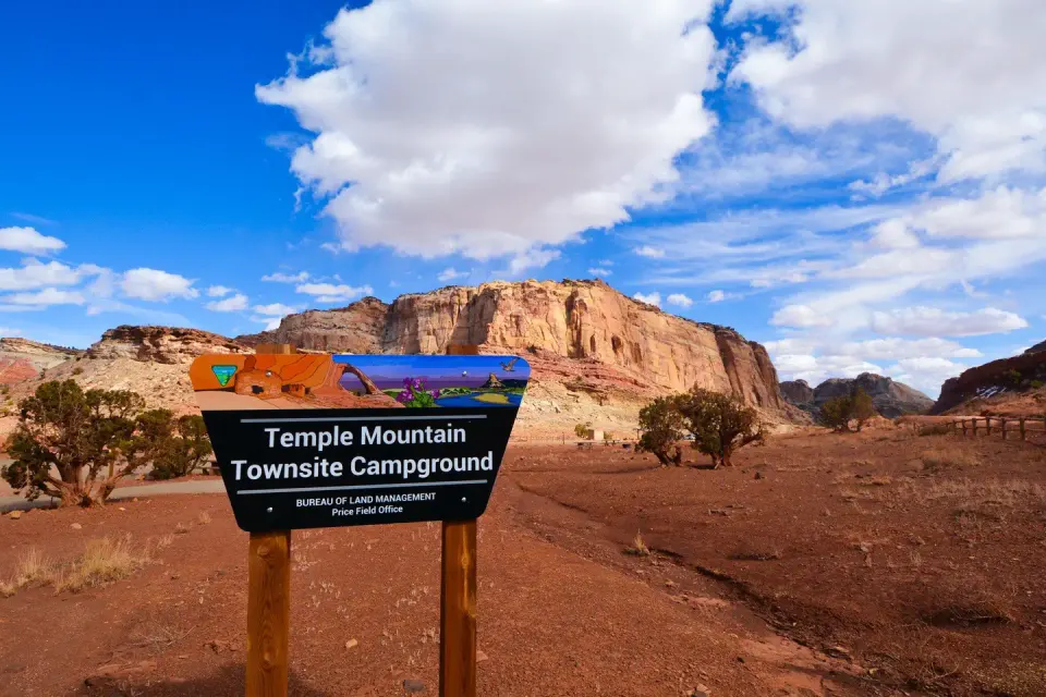 Sign for Temple Mountain Townsite Campground with a cliff in the background