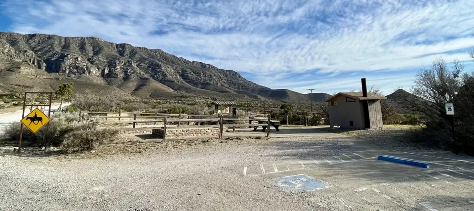 Frijole Horse Corral Campsite with RV parking spaces in the foreground, tent pads, picnic table and restroom are shown.